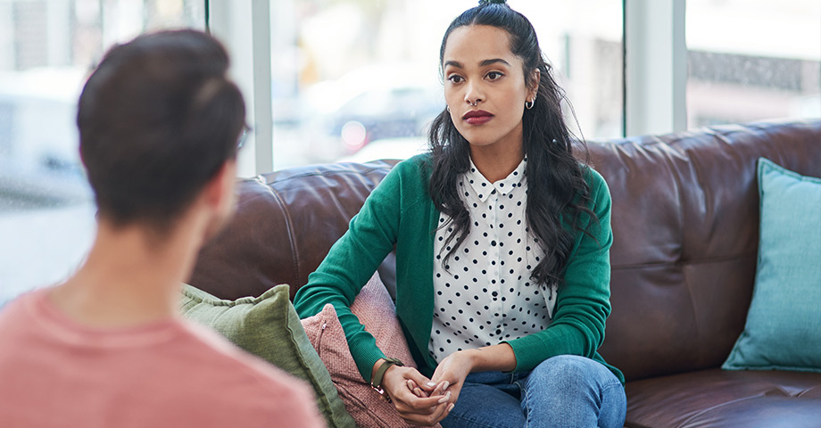 Female therapist speaks with male patient during session.