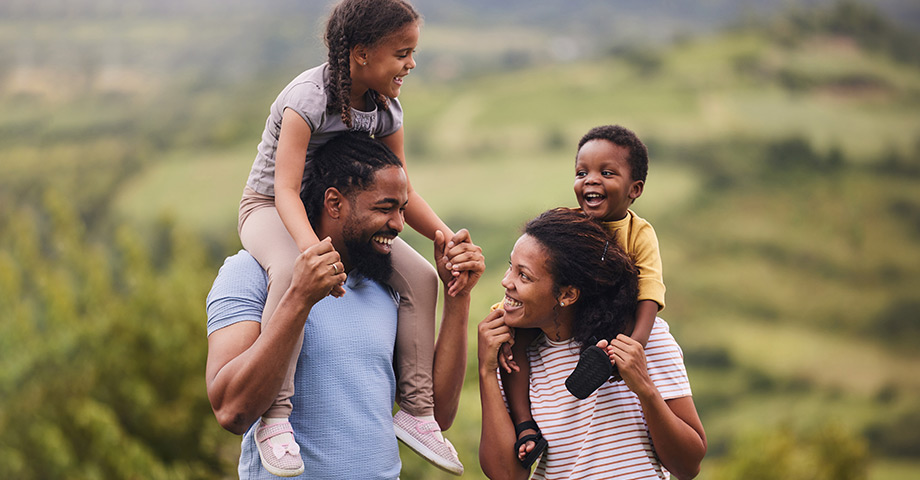 Kids on Dad and Mom shoulder out for a hike