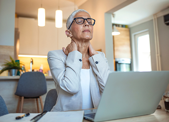 Woman holding her hands on her shoulders while researching options for menopause support