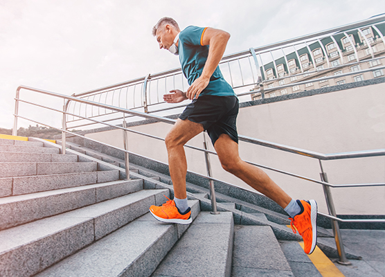Man in bright orange shoes running up stairs outside
