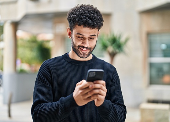 Man in long sleeve shirt researching different wellness support options on his phone