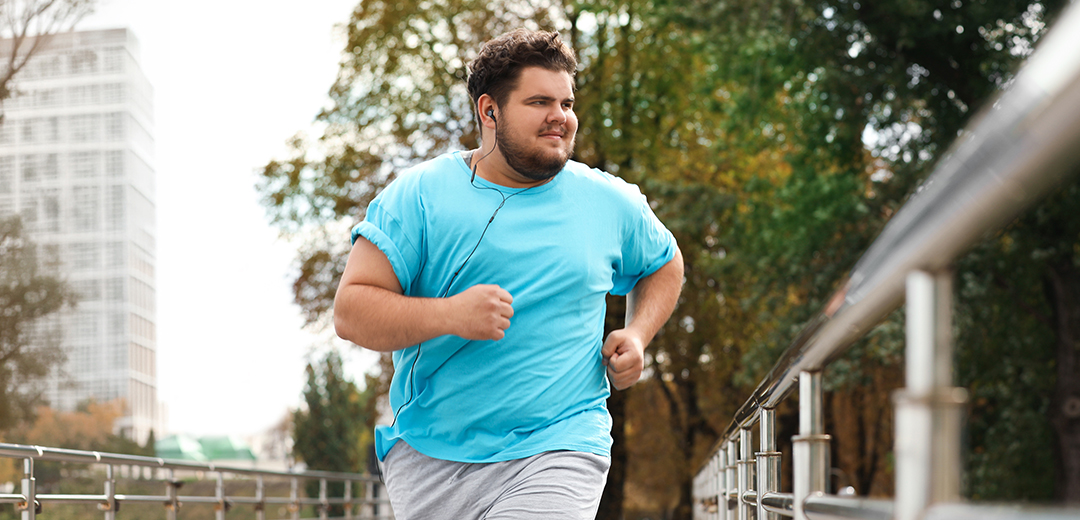 A gentleman running on the sidewalk working on himproving his health