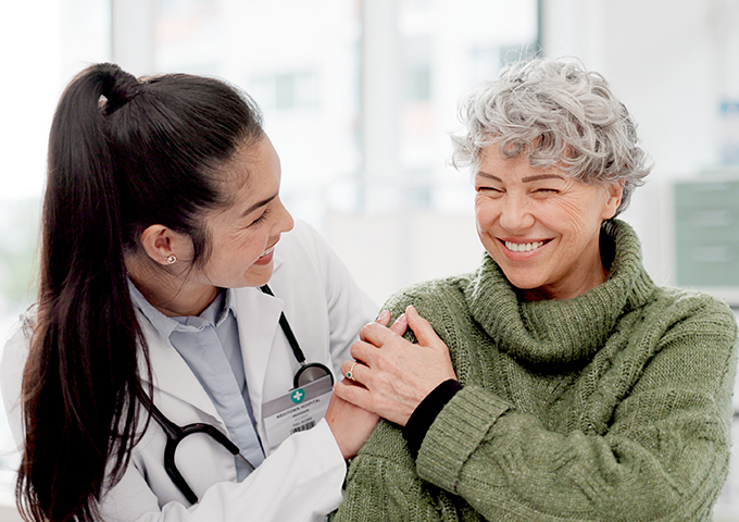 Female doctor consults a smiling patient in a bright office, showing how trusted care and communication supports better health outcomes.