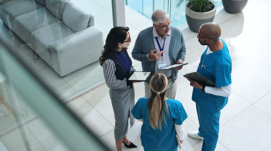 Overhead view of a group of healthcare professionals discussing a case.