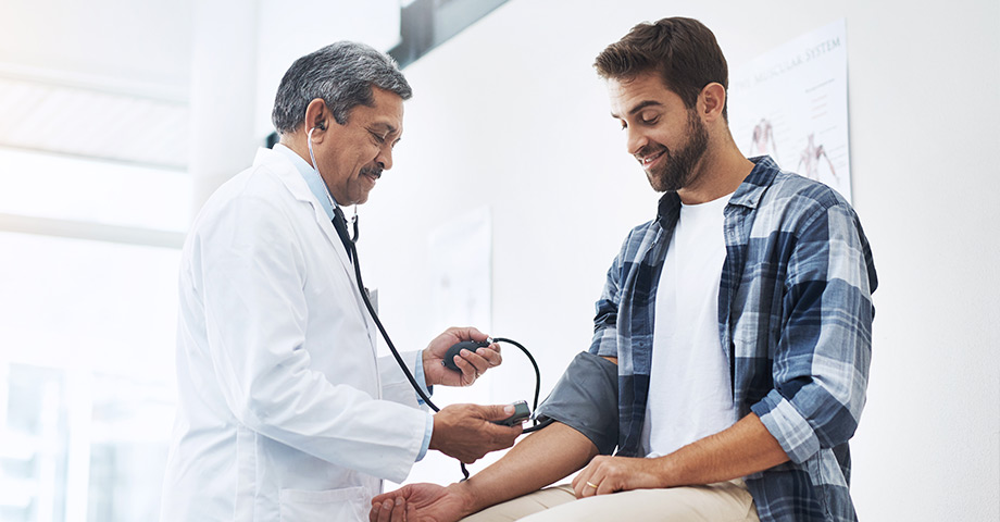 A doctor taking the blood pressure of his patient.