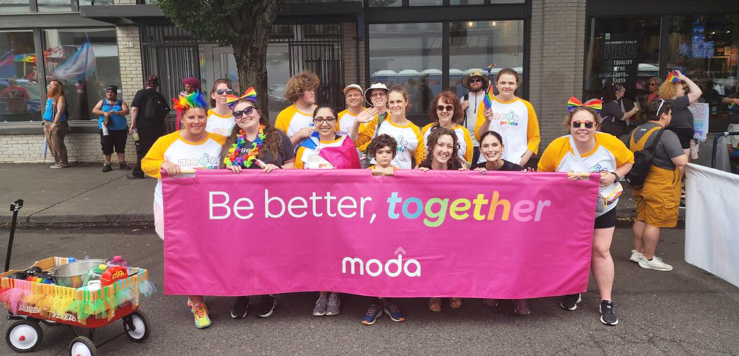 Moda Health volunteers hold a “Be better, together” banner during the Pride Parade.