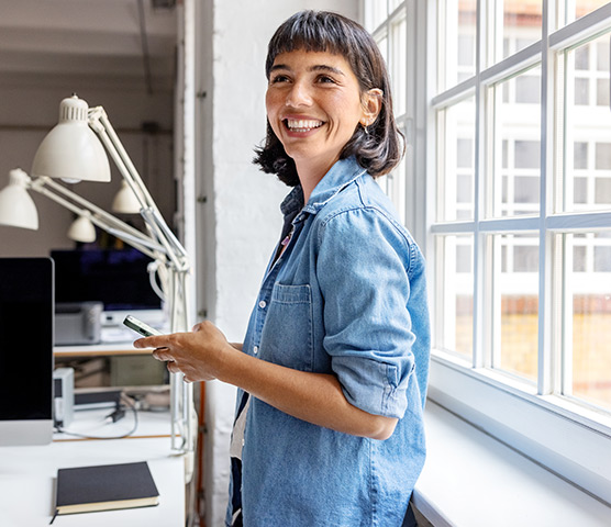 A young female professional smiles warmly at the camera.