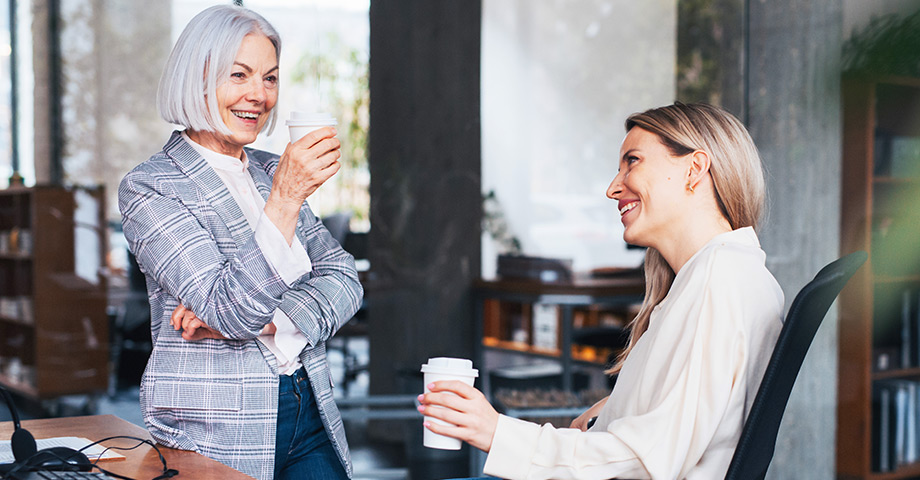 Two women talking at work and smiling