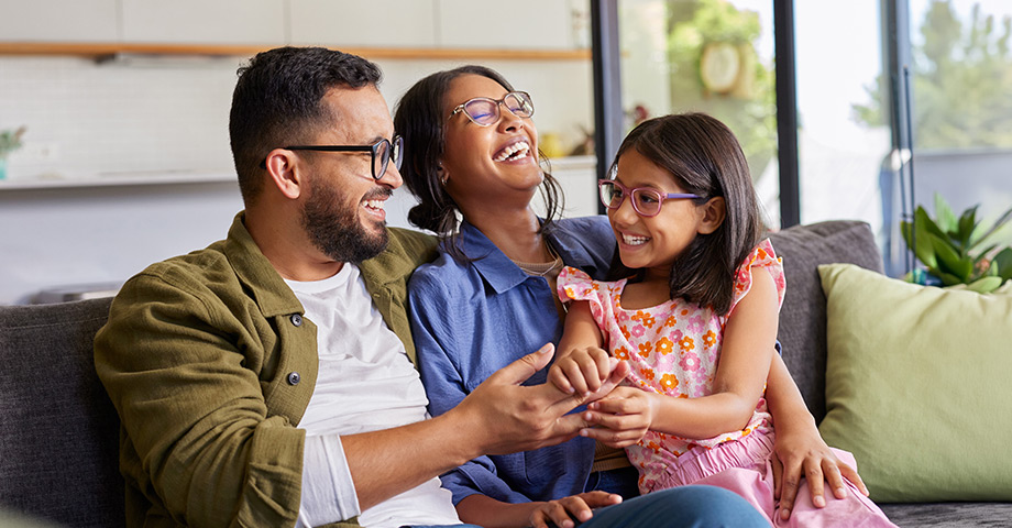 A family sitting and laughing on the couch together
