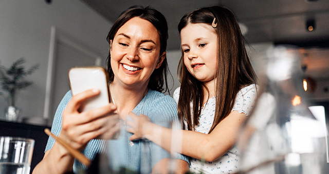 A mother and daughter looking at a smartphone