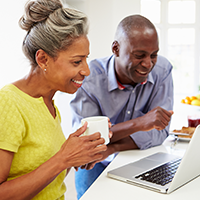 Smiling couple looking at laptop