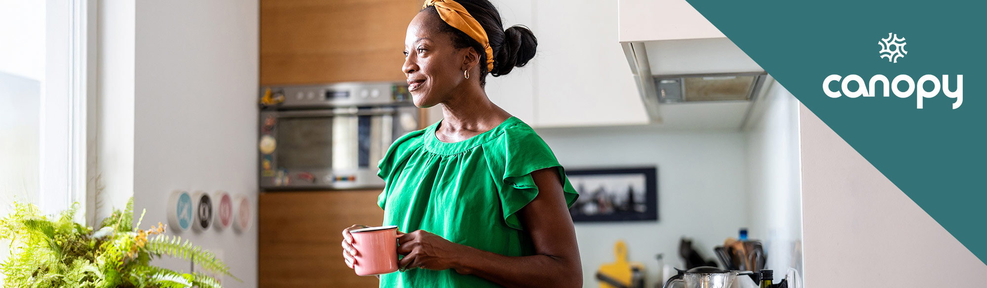 A woman in her kitchen enjoying a cup of coffee