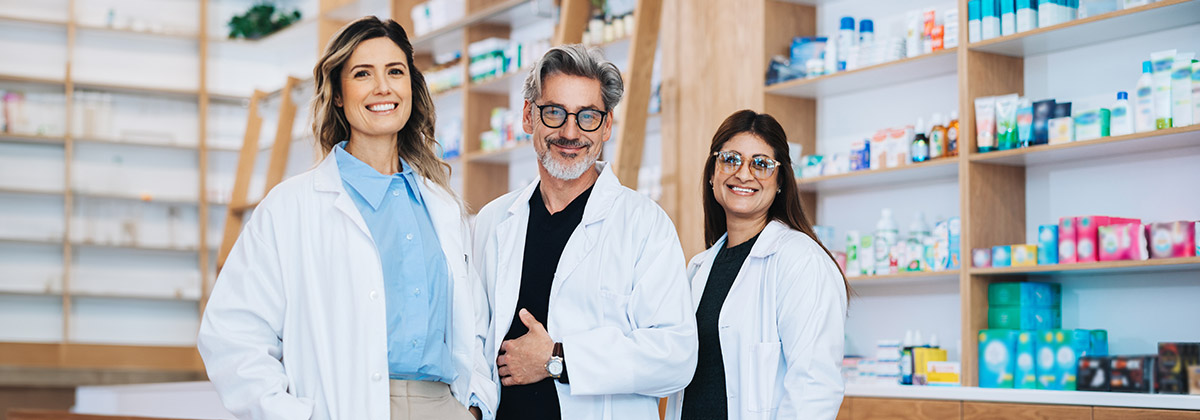 A group of three pharmacist smiling at work