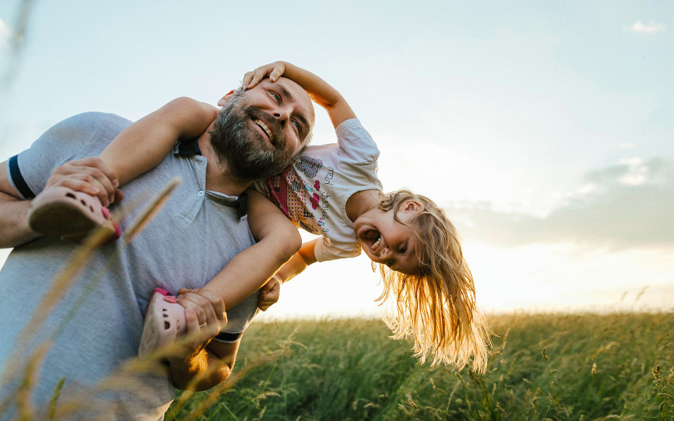 A daughter sitting on her father's shoulders