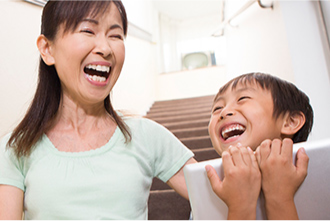 Woman and child sitting on stairs, laughing